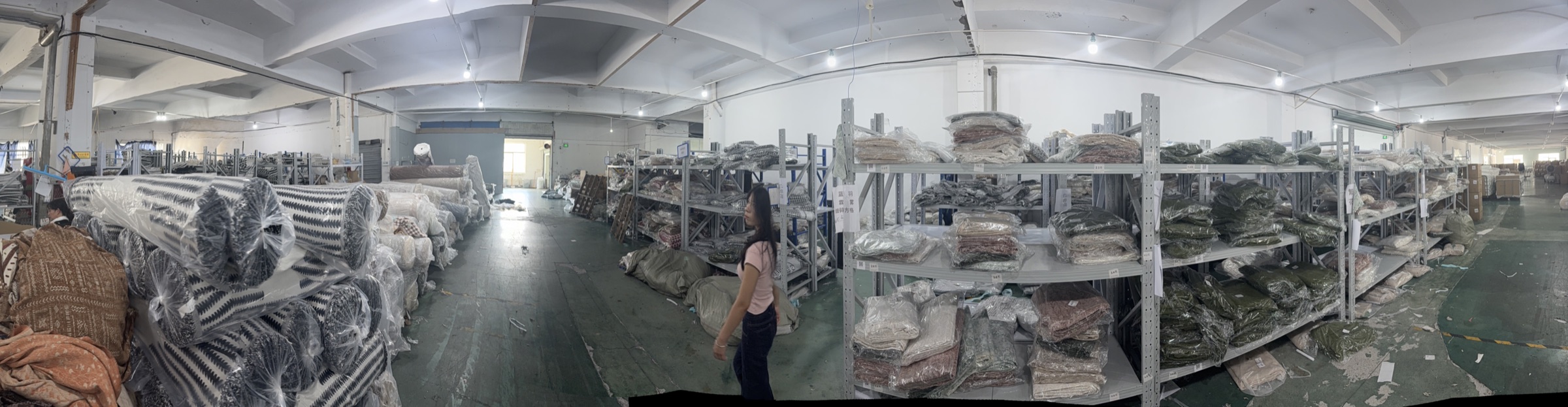 Warehouse shelving with packaged sofa covers and textile rolls